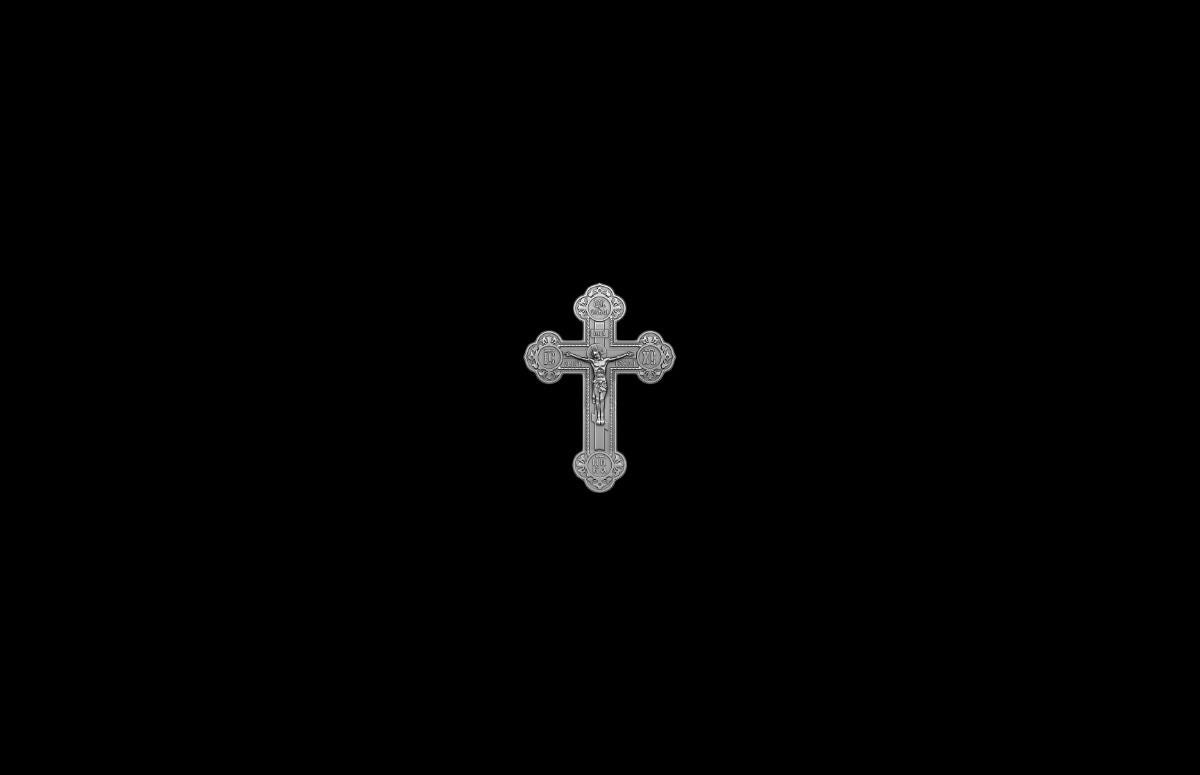 Silver cross pendant on a black background 